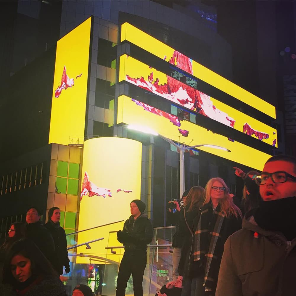 Mountain Light Time on the Times Square screens at night.
